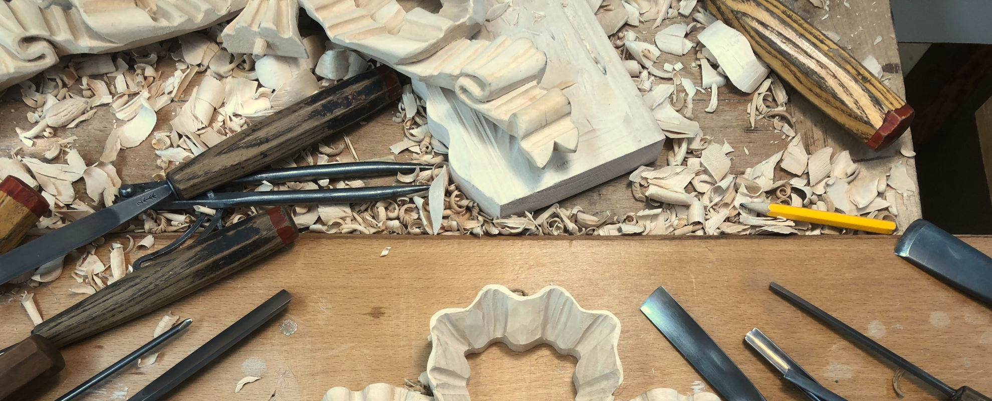 Close-up of hands working on wood carving in a workshop