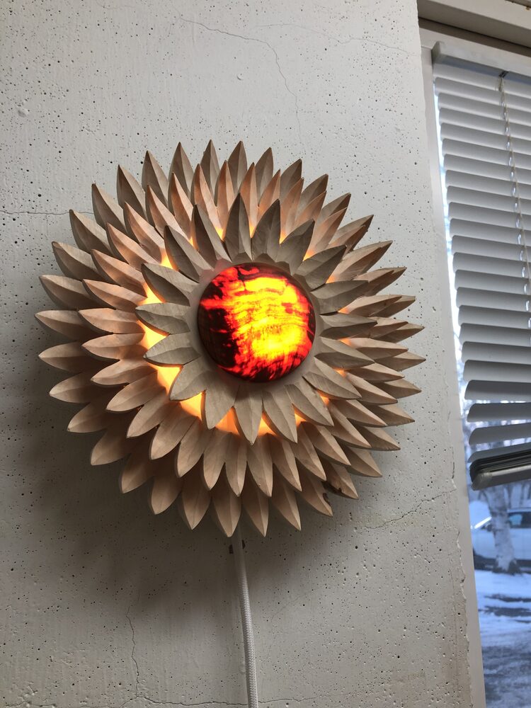 Vägglampa i lind med ljuset på närbild